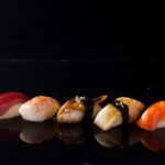 Row of Japanese sushi on black background with copy space